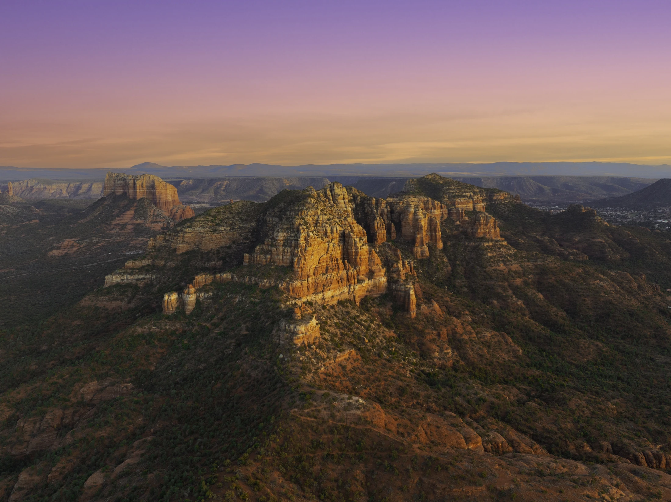 Aerial view of Sedona’s red rock landscape in warm sunset light