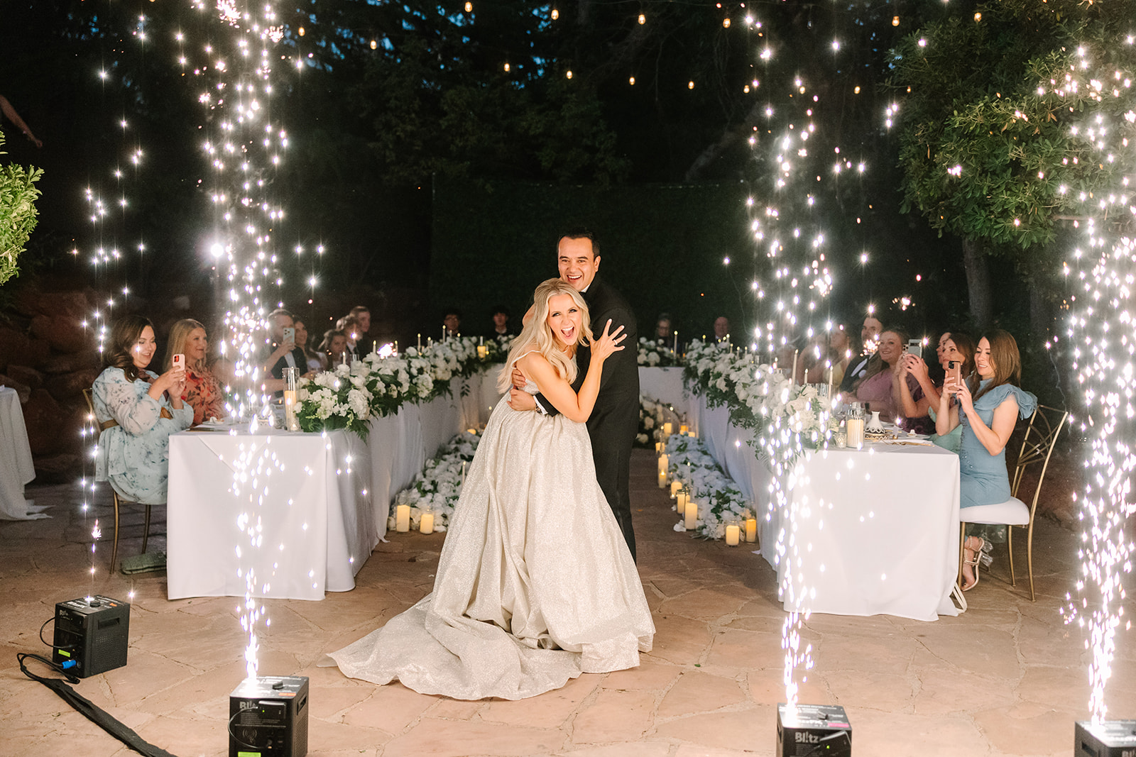 Shana and Kamal entering their wedding reception between sparkler fountains