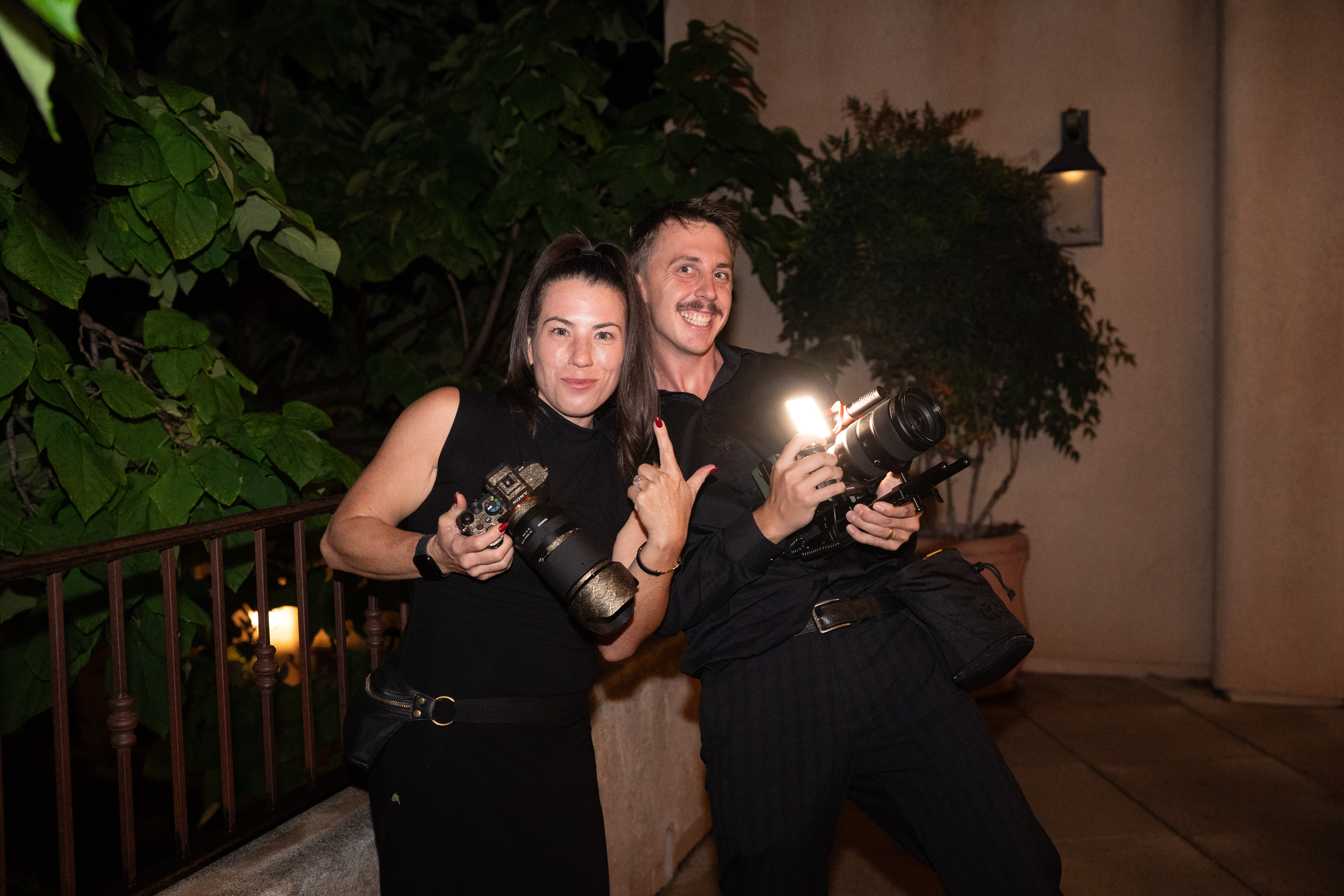 Shannon Roberts and team member Garrett Teague holding their cameras at a wedding